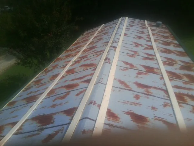 Rusted metal roof panels with new wood purlins before replacement — Storm Damage Roof Repair in Camden by Roofing Brothers